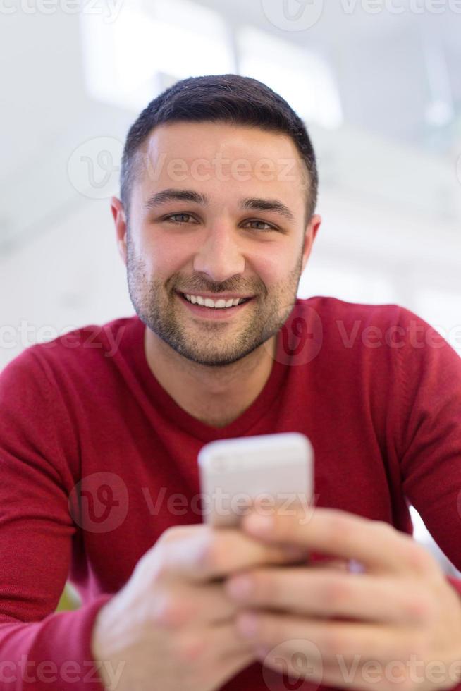 young man using a mobile phone  at home photo