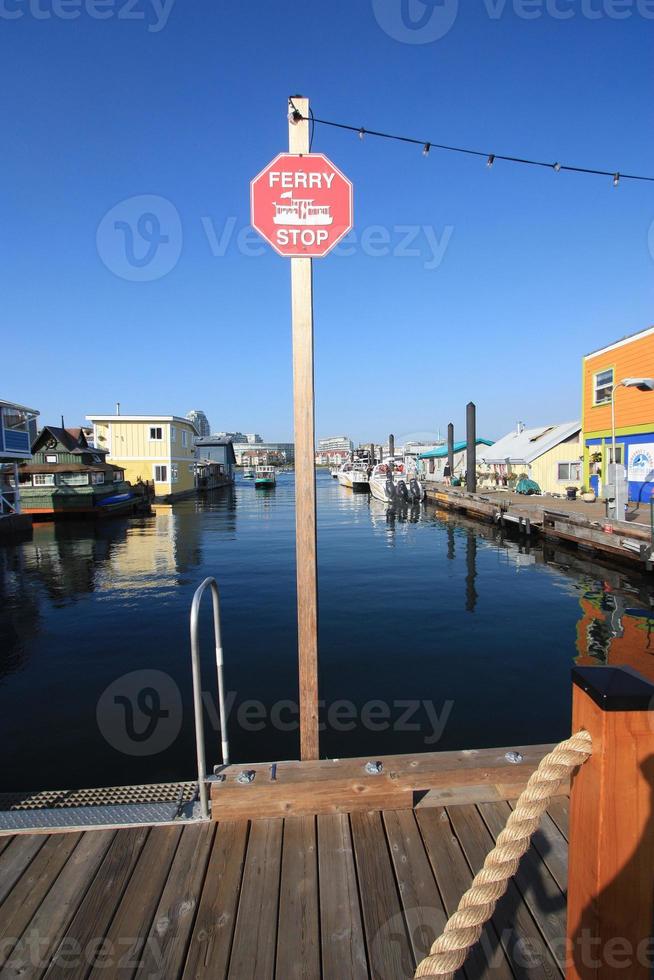 A ferry stop sign on a pier between float homes. photo