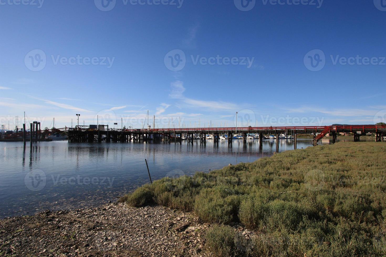 A pier with boats in the distance in a small fishing village. photo