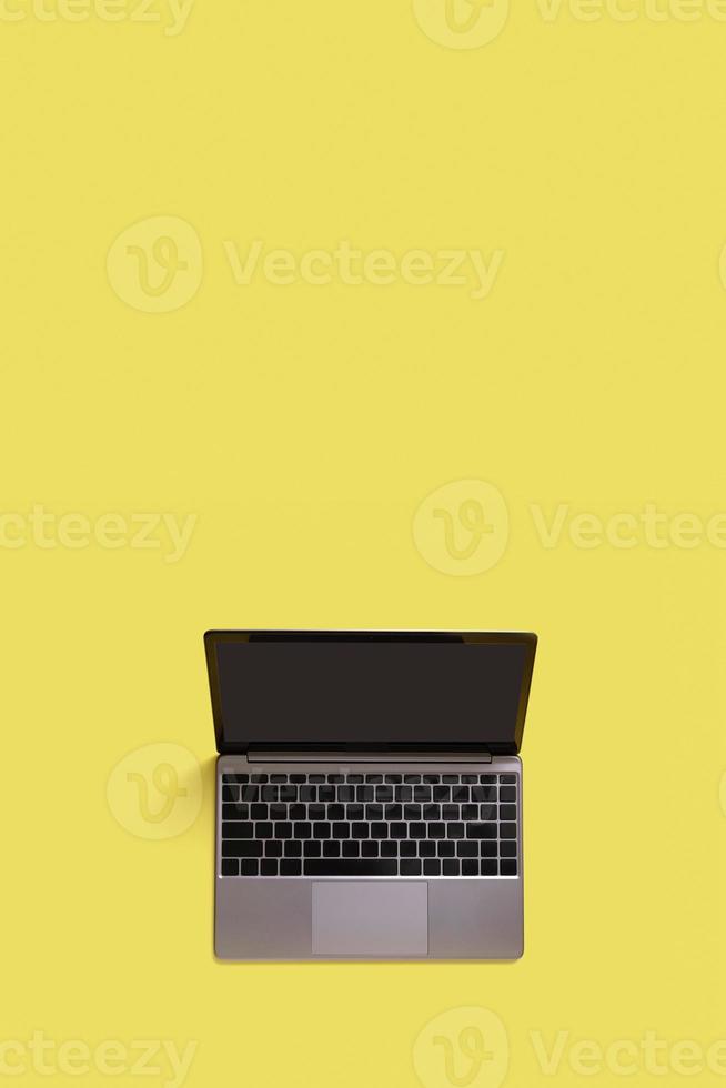 Top view of modern laptop isolated on yellow background. Copy space photo