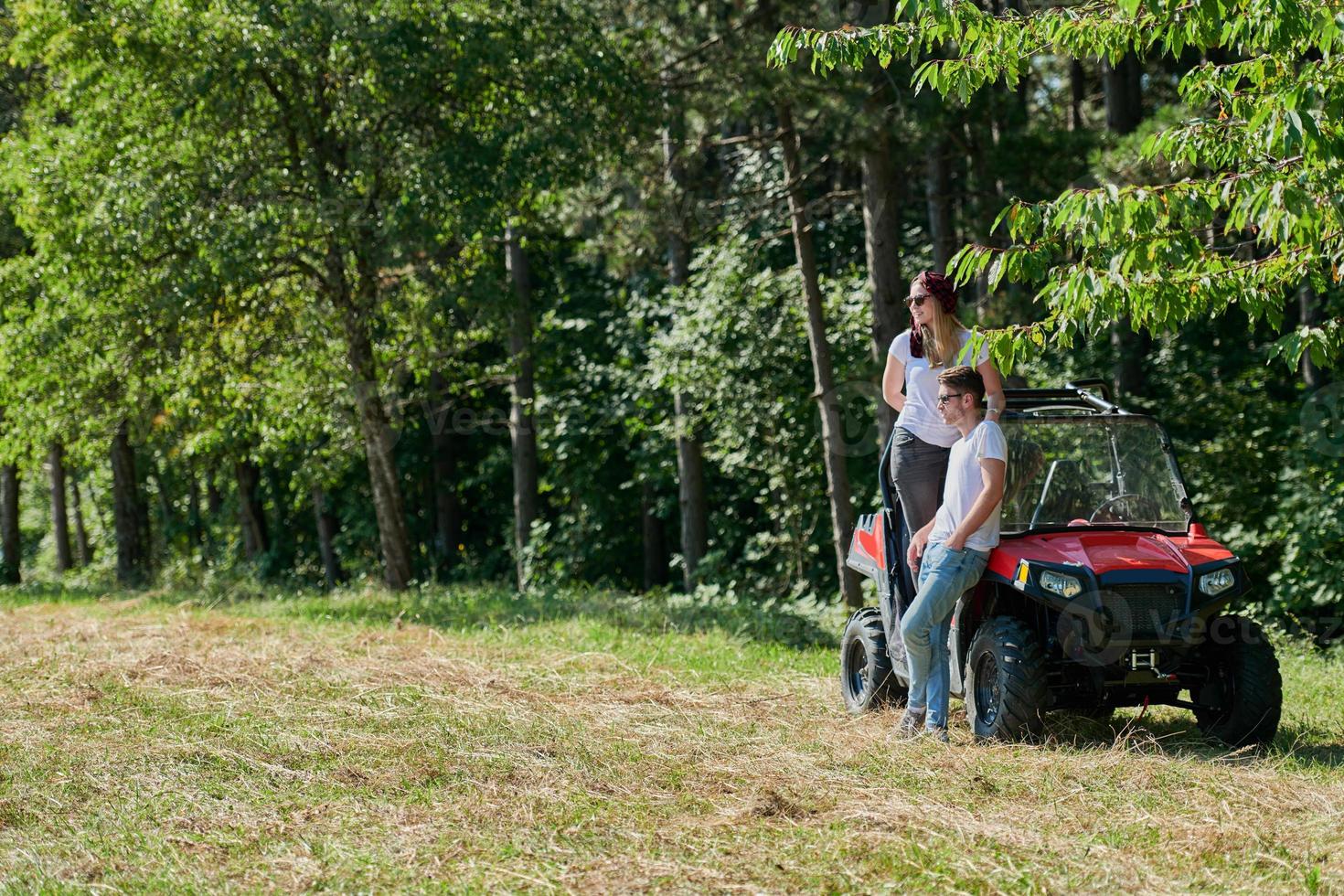 couple enjoying beautiful sunny day while driving a off road buggy photo