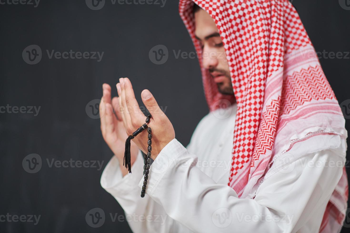 Arab man in traditional clothes praying to God or making dua photo