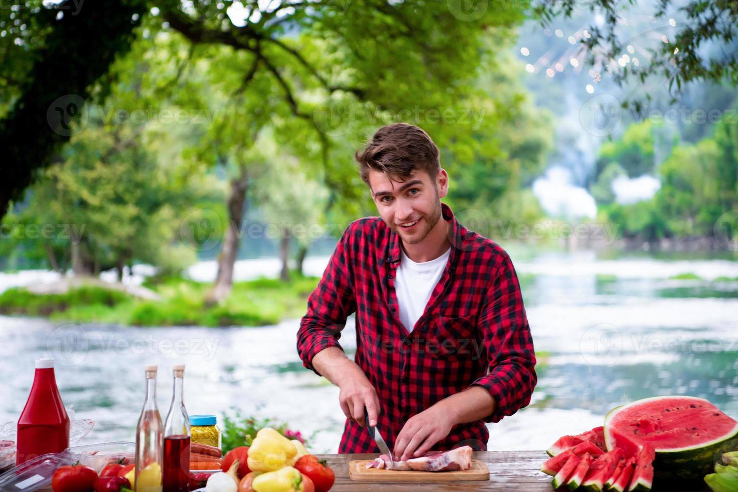 Man cutting meat for barbecue grill photo