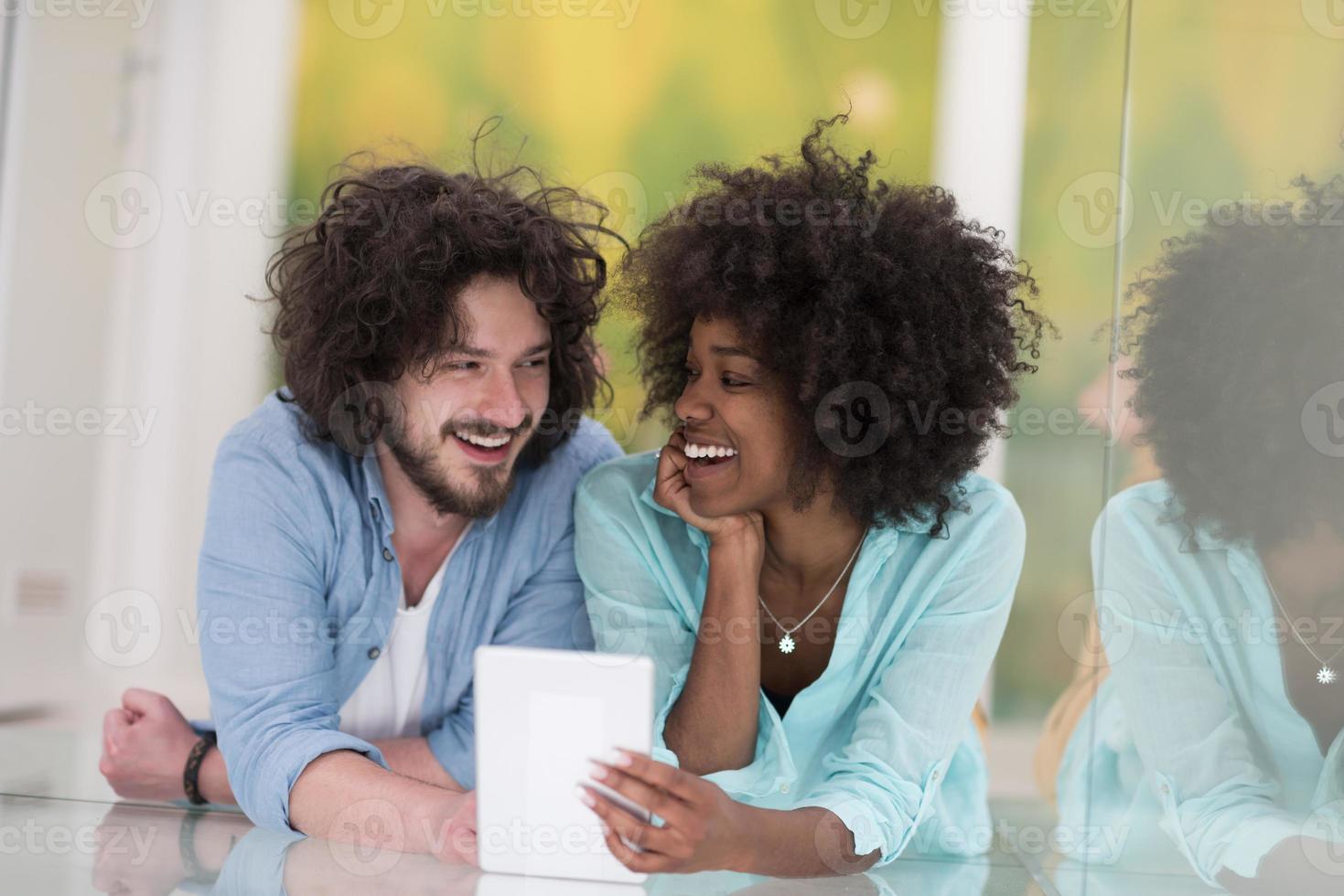 pareja relajándose juntos en casa con una tableta foto