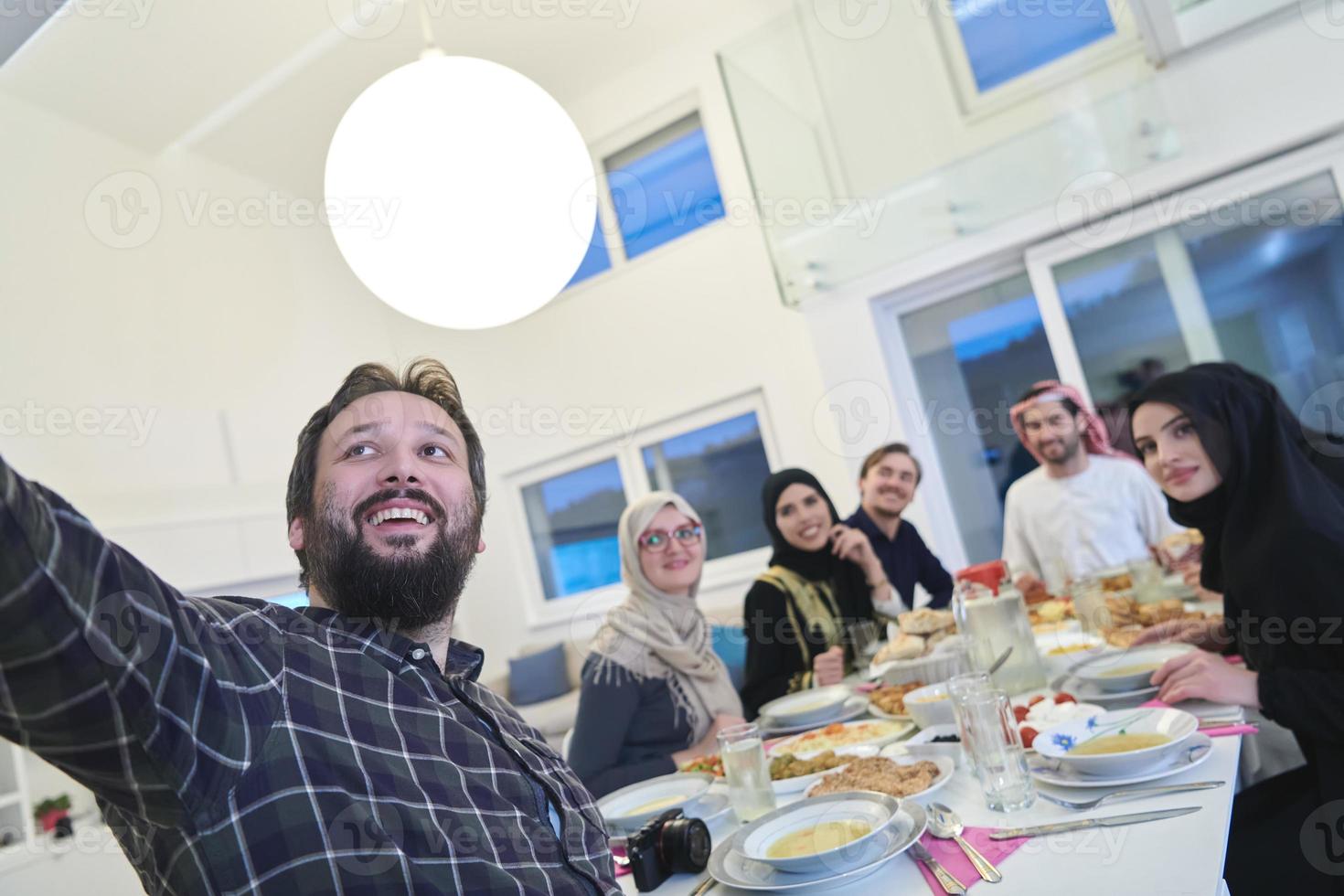 Muslim family taking selfie while having iftar together during Ramadan photo