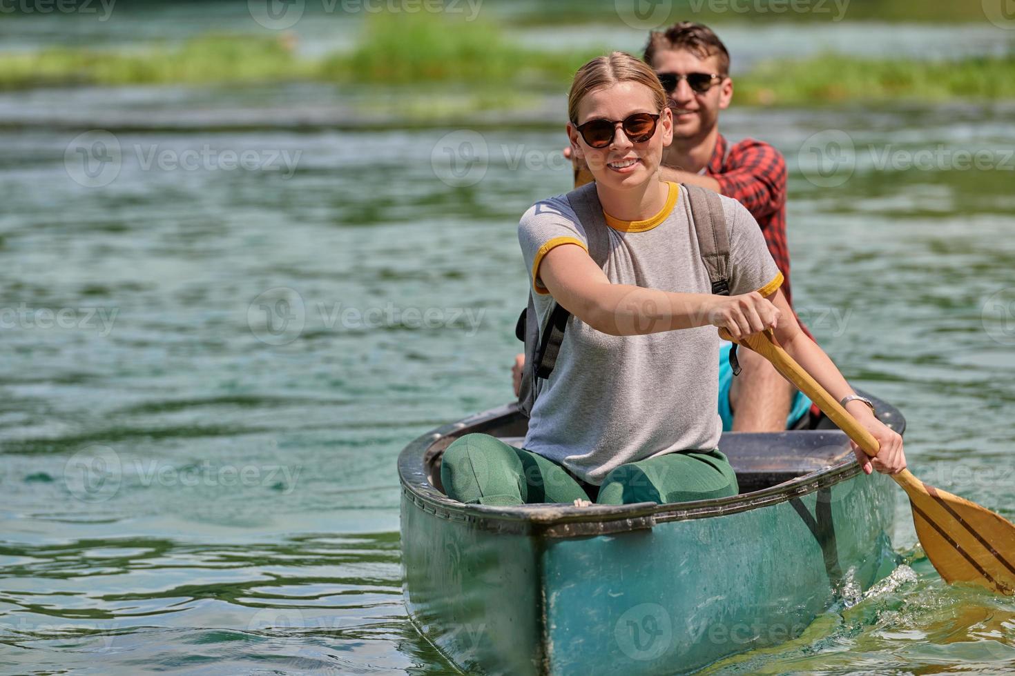 friends are canoeing in a wild river photo