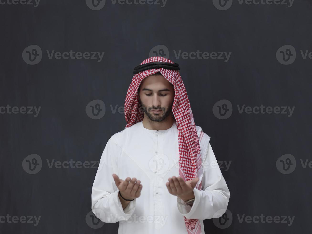 Arab man in traditional clothes praying to God or making dua photo