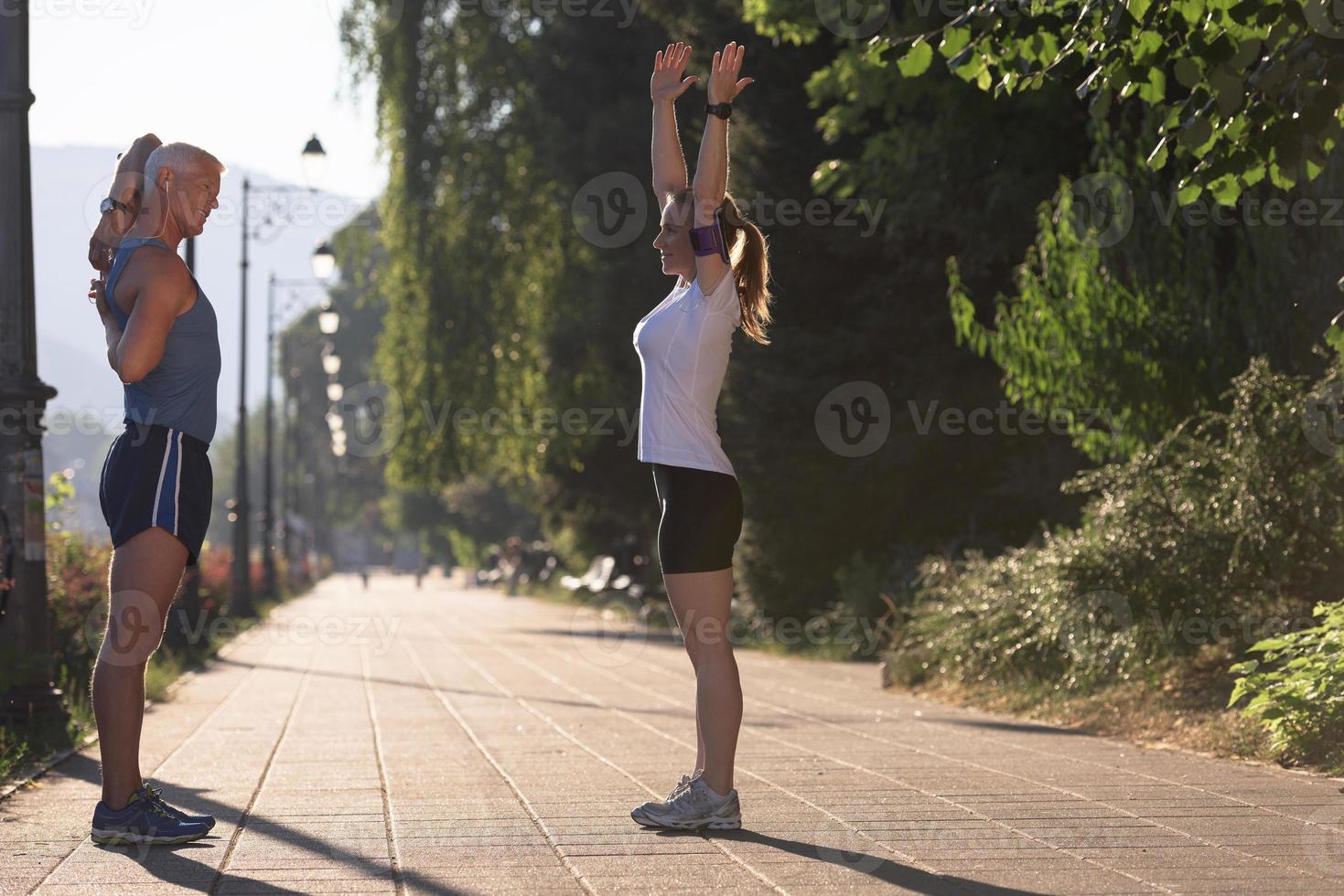 couple warming up and stretching before jogging photo