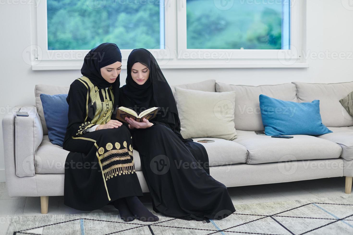 Portrait of young muslim women reading Quran in modern home. photo