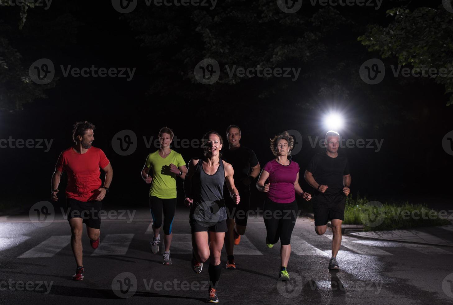 equipo de corredores en el entrenamiento nocturno foto