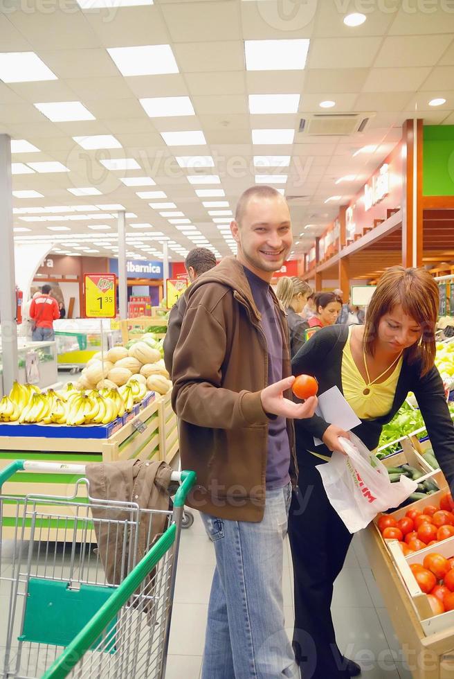 pareja feliz comprando frutas en el hipermercado foto