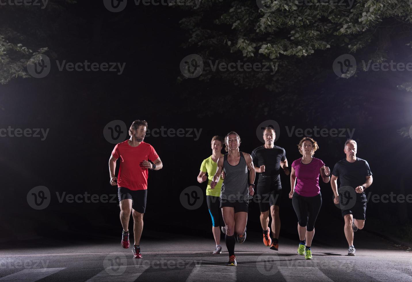 equipo de corredores en el entrenamiento nocturno foto