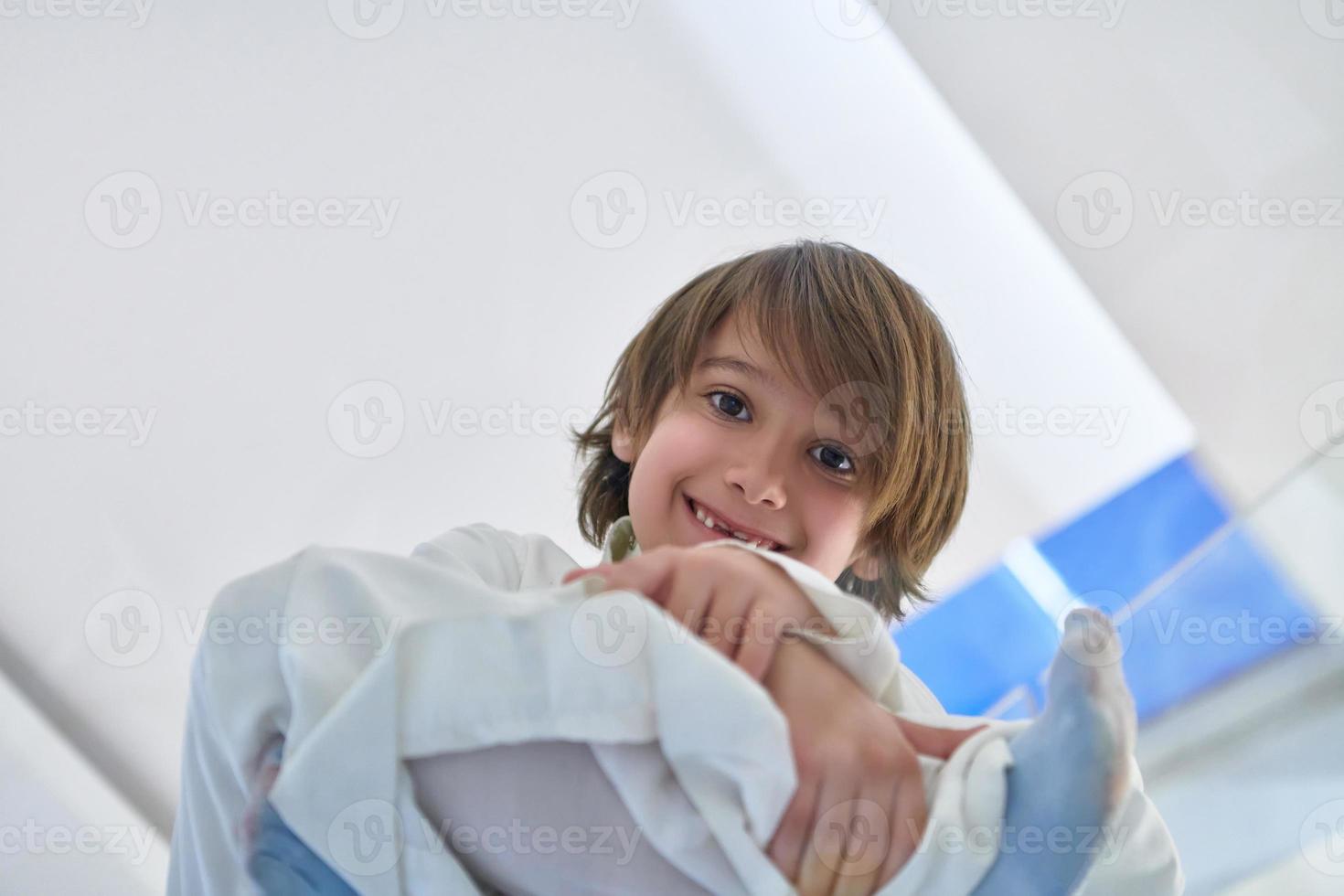 Portrait of arabian kid wearing traditional clothes sitting on the glass floor photo