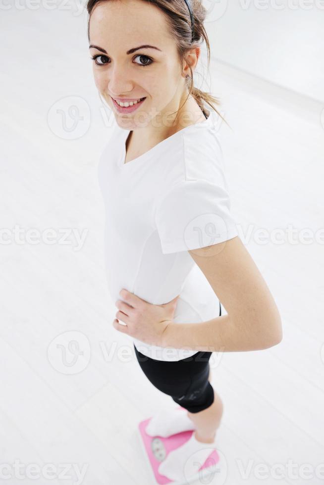 happy diet concept with young woman on pink scale photo