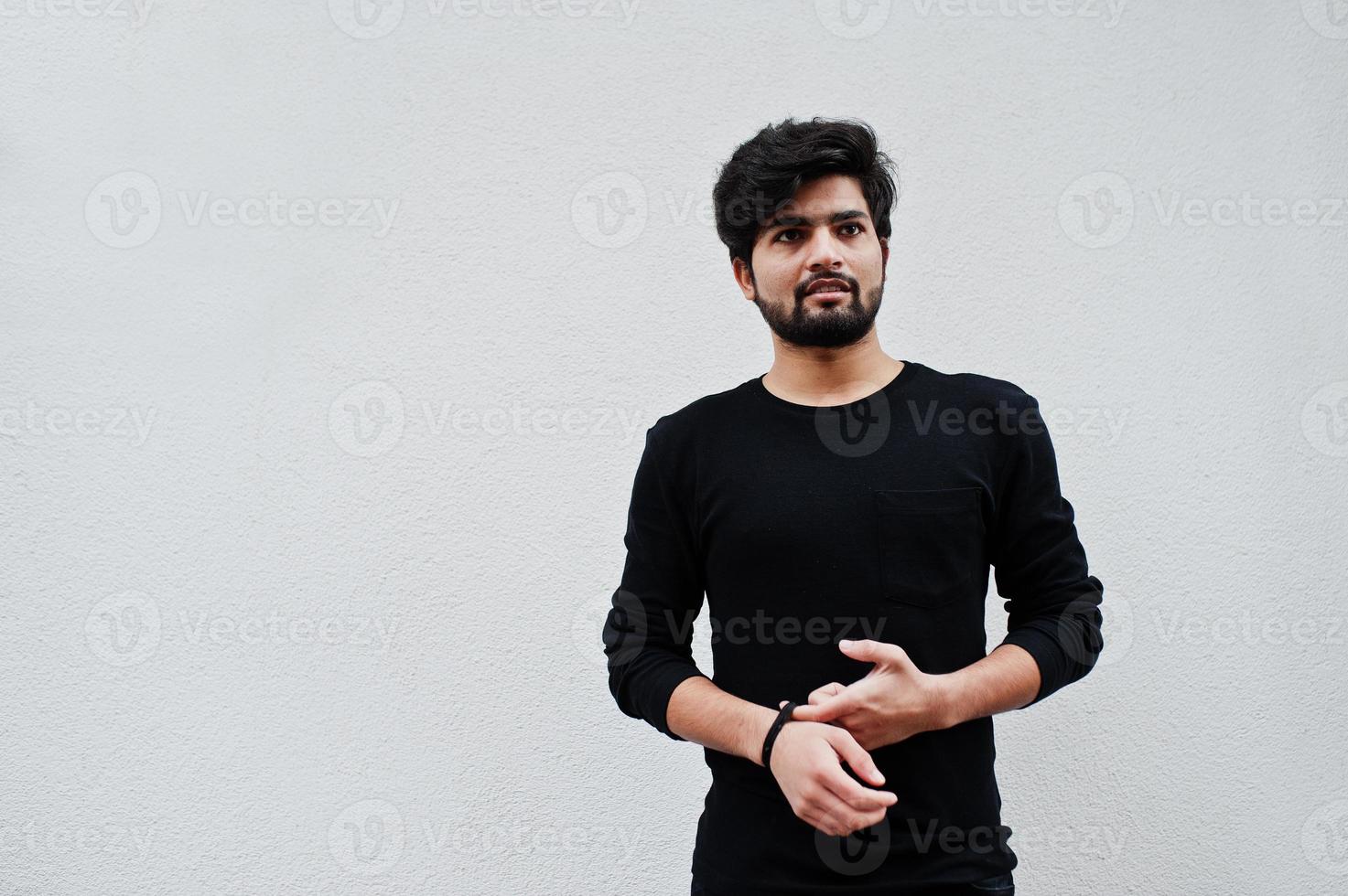 Urban young hipster indian man in a fashionable black show bracelet beads. Cool south asian guy. photo