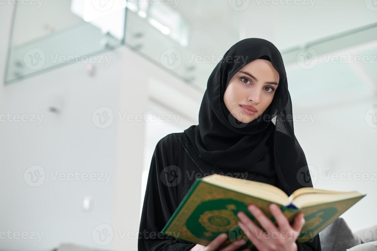 retrato de una joven musulmana leyendo el Corán en un hogar moderno foto