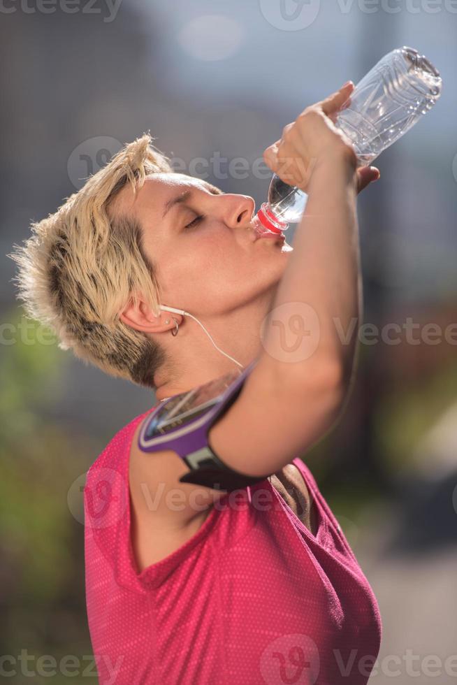 woman drinking  water after  jogging photo
