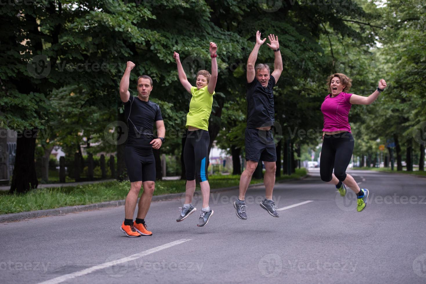 runners team jumping in the air during  morning training photo