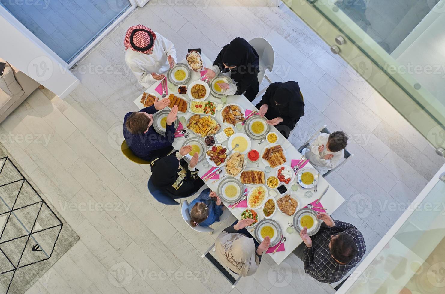 Top view of Muslim family making iftar dua to break fasting during Ramadan. photo