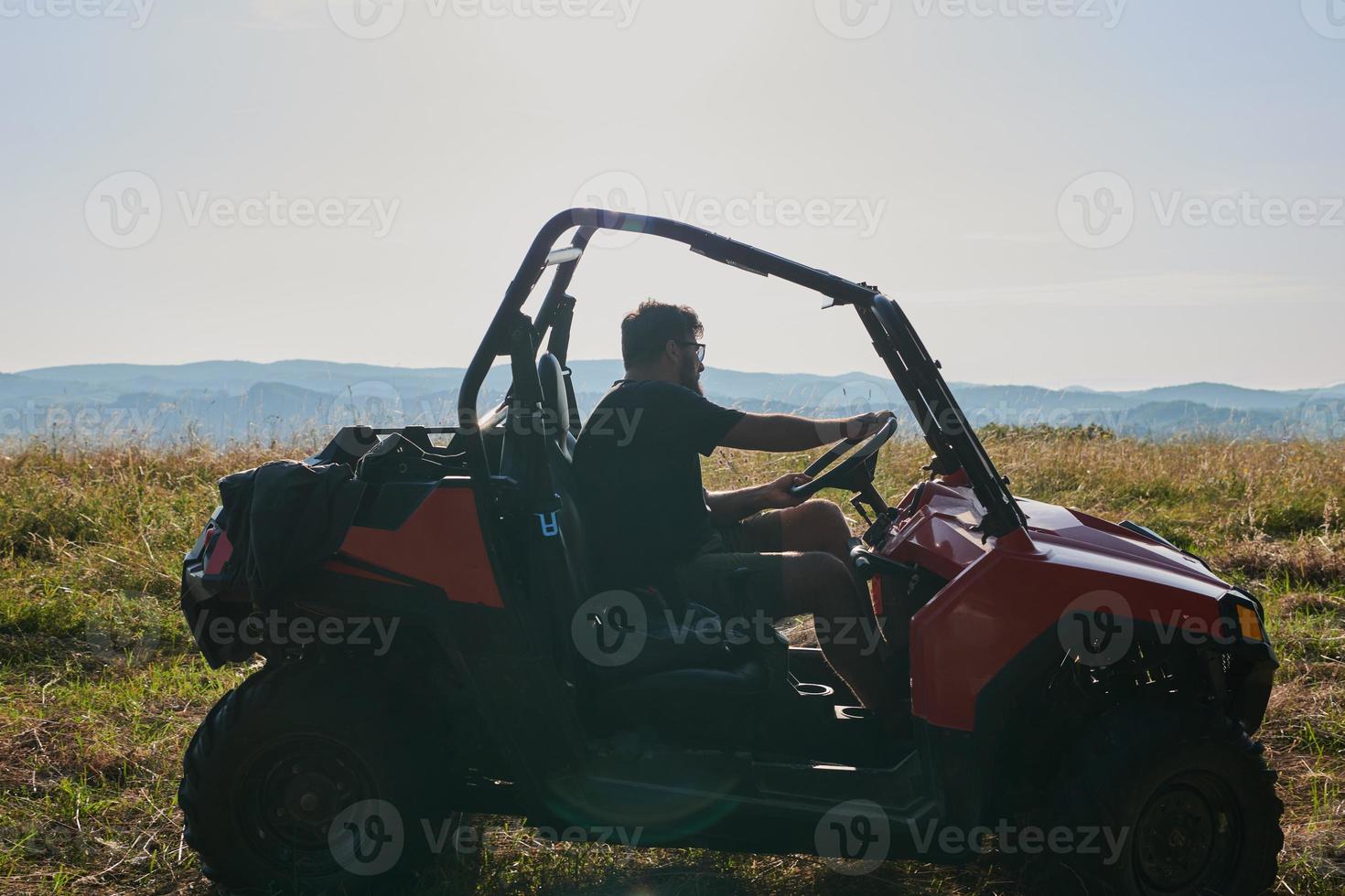 man enjoying beautiful sunny day while driving a off road buggy car photo