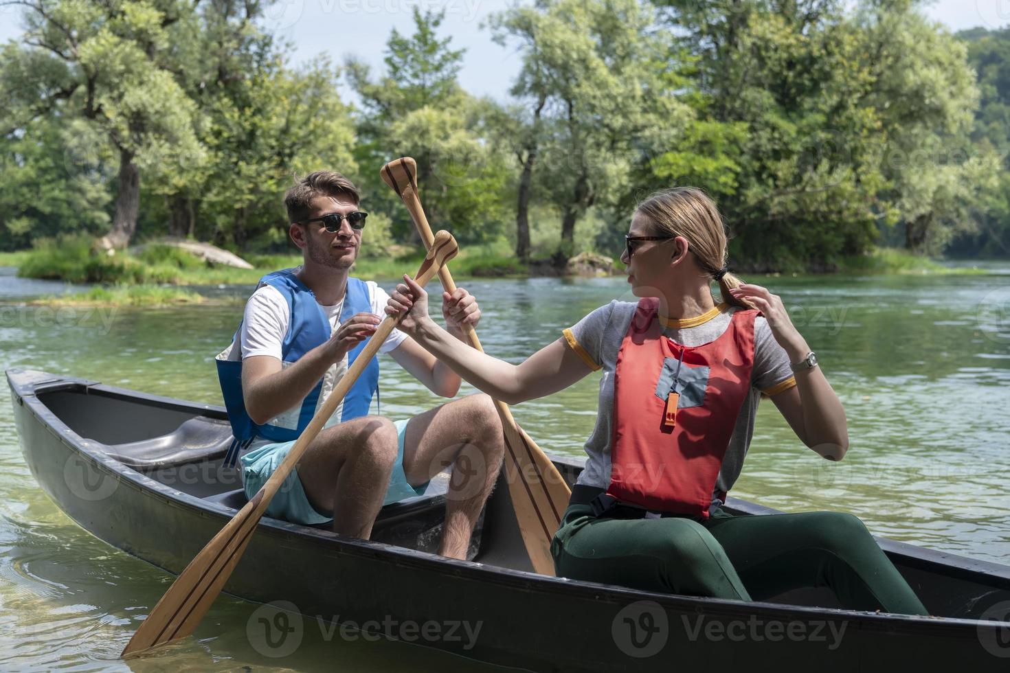 friends are canoeing in a wild river photo