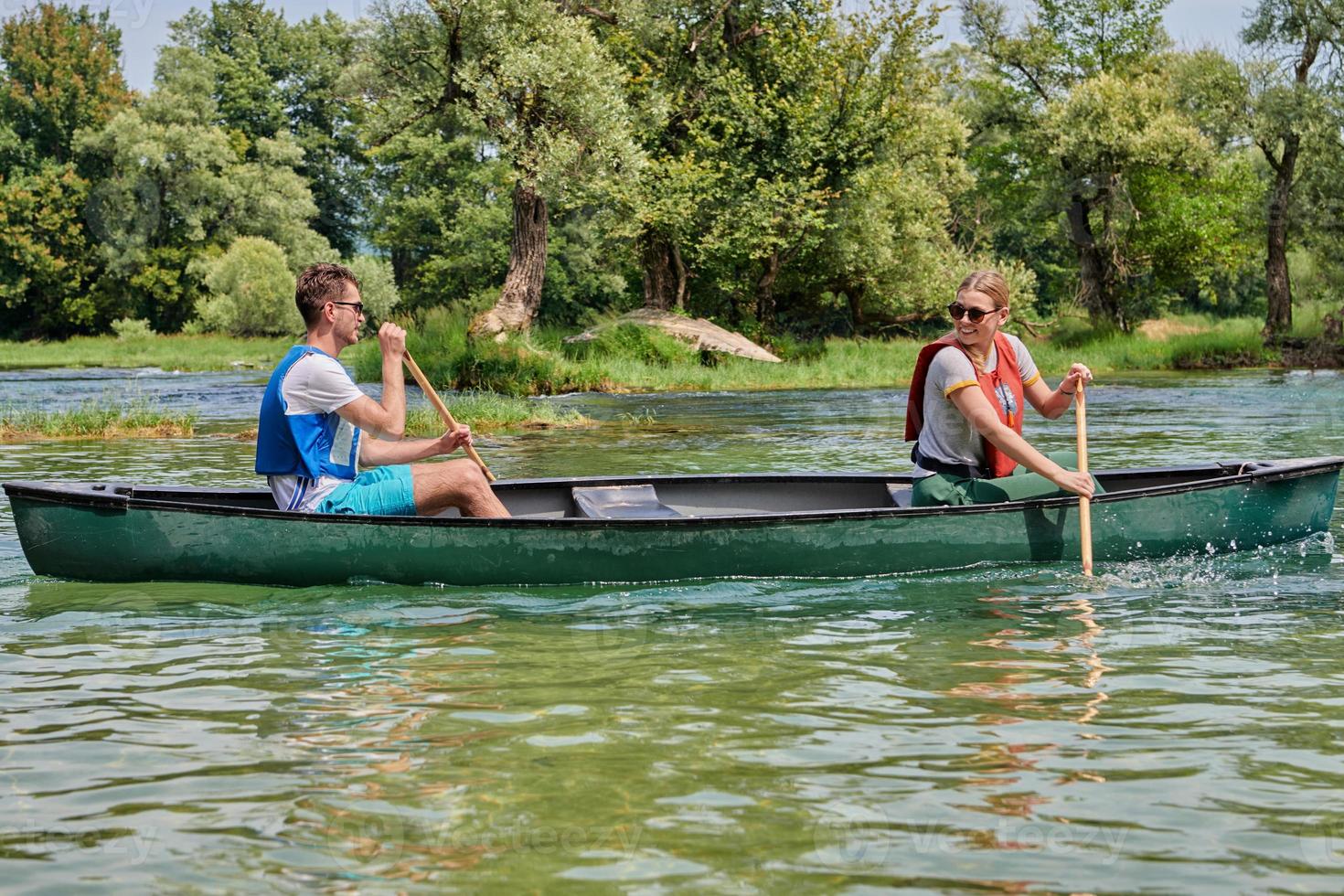 friends are canoeing in a wild river photo