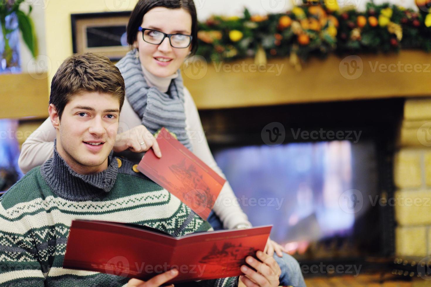 Young romantic couple relax on sofa in front of fireplace at home photo