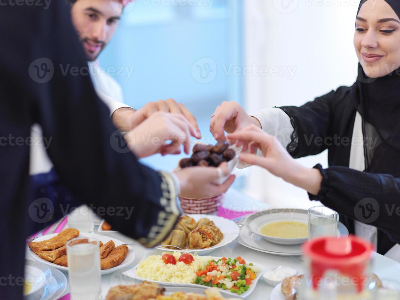 Muslim family having Iftar dinner eating dates to break feast photo