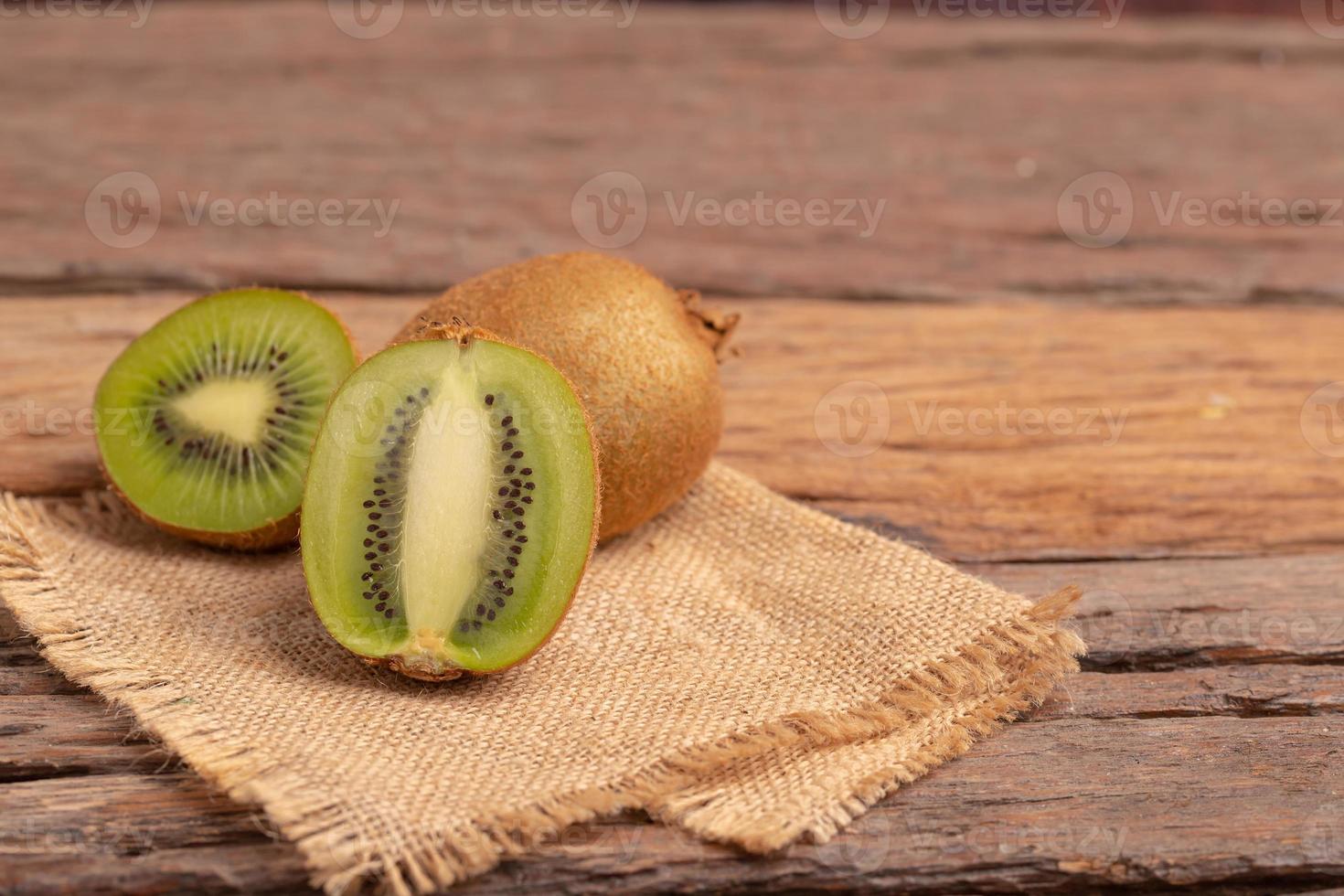 la mitad de kiwi colocado en el saco marrón foto