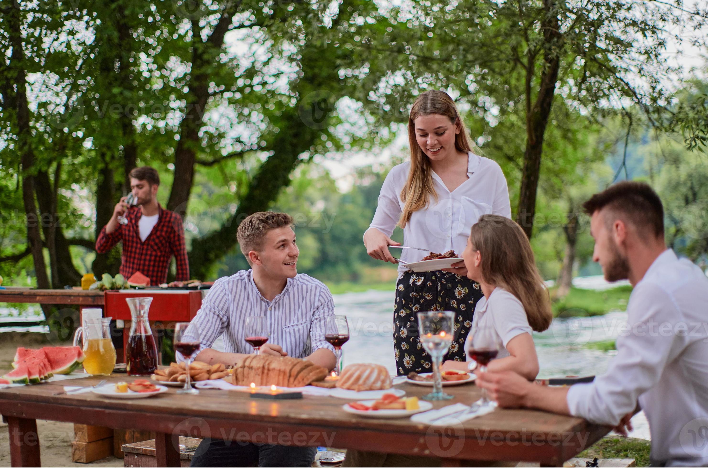 friends having picnic french dinner party outdoor during summer holiday
