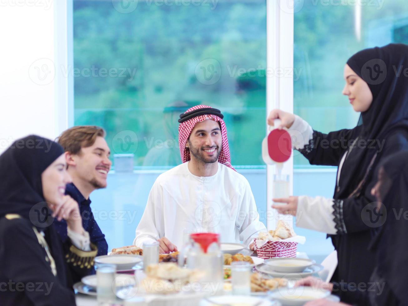 Muslim family having Iftar dinner drinking water to break feast photo