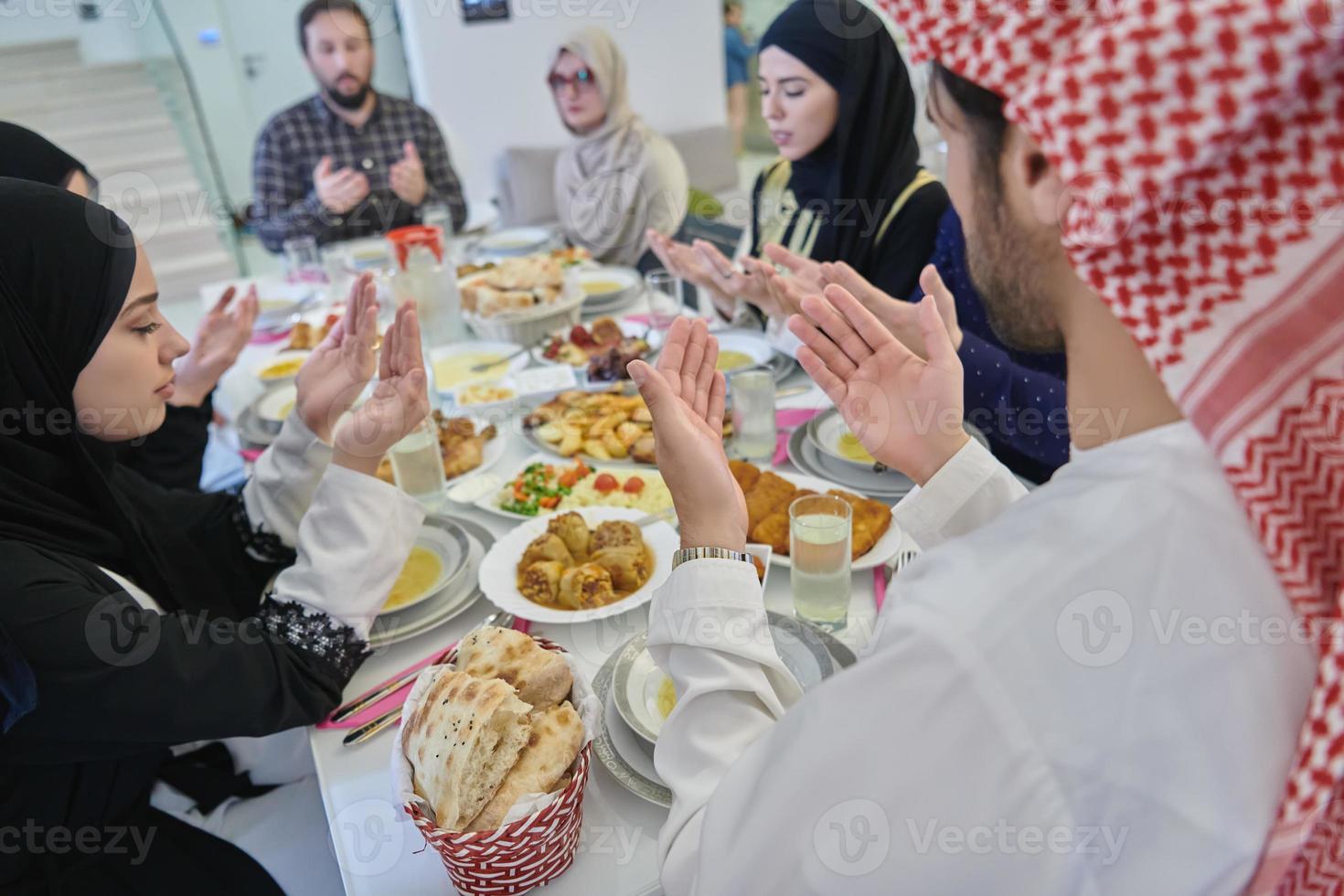 familia musulmana haciendo iftar dua para romper el ayuno durante el ramadán. foto