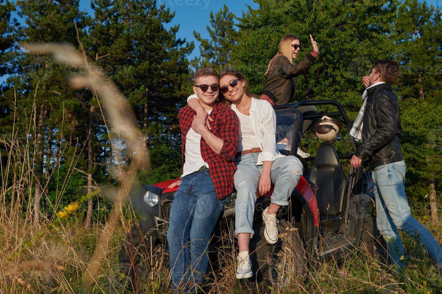 group young happy people enjoying beautiful sunny day while driving a off road buggy car photo