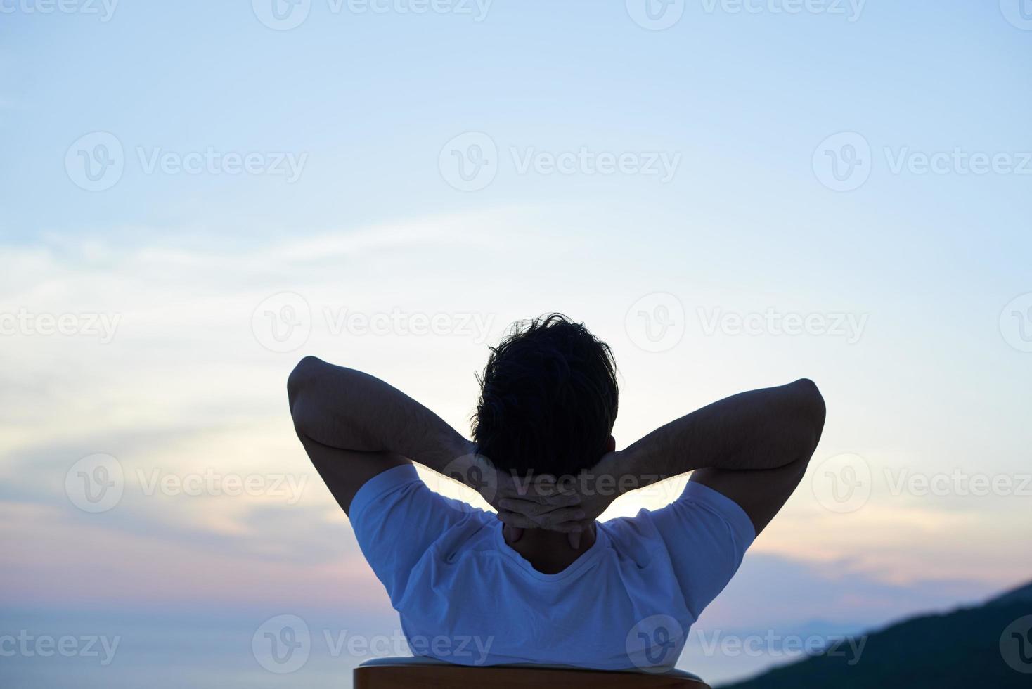 relaxed young man at home on balcony photo