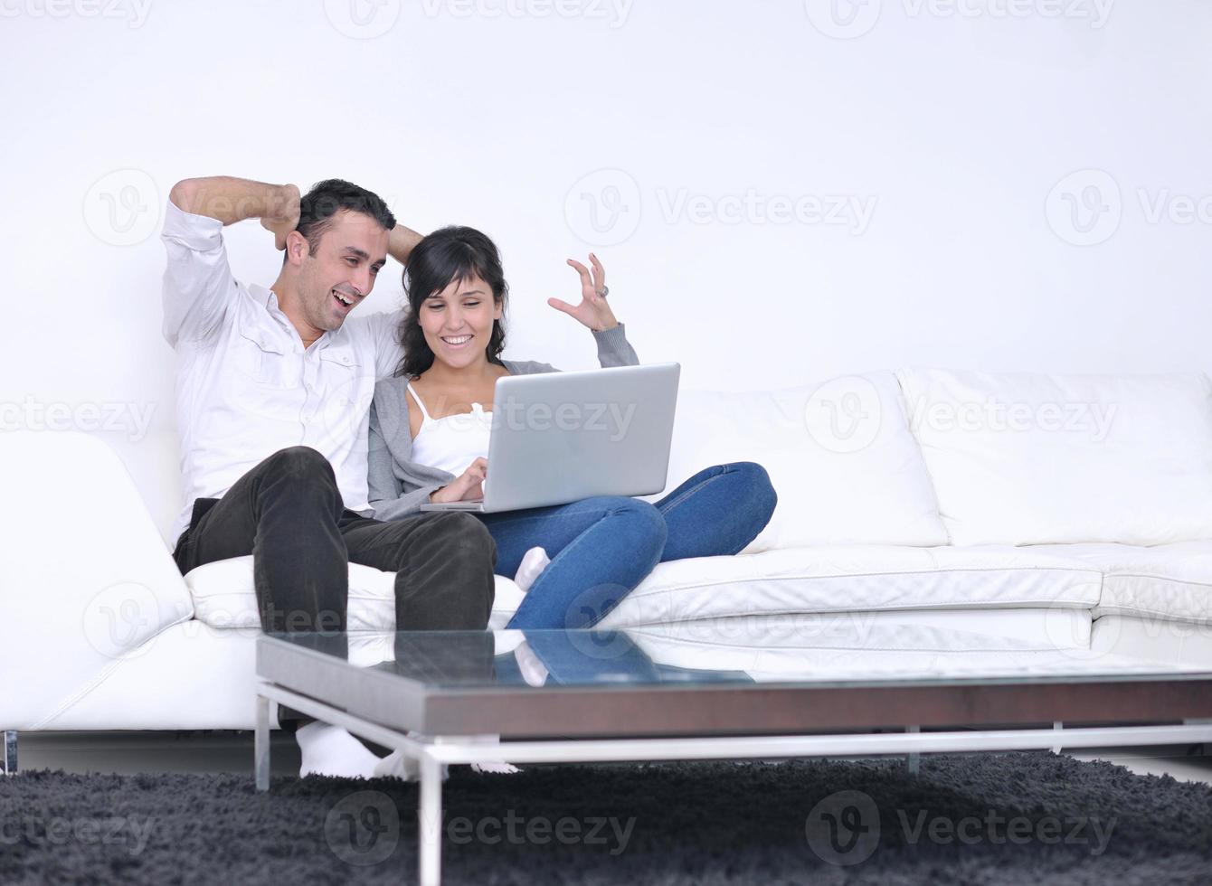 joyful couple relax and work on laptop computer at modern home photo