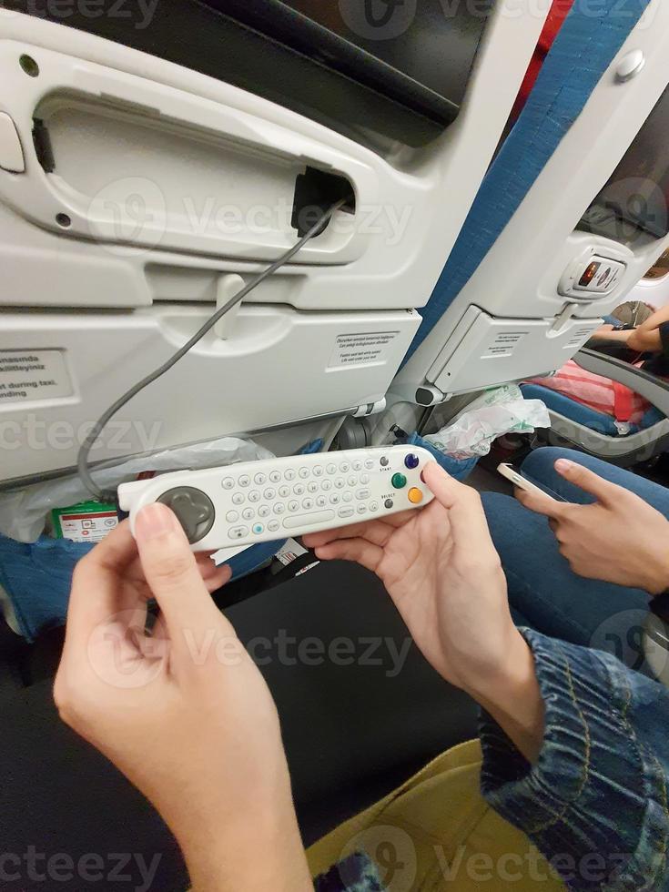 The interior of the passenger seat of a Turkish Airlines plane that has a touch screen for in-flight entertainment. Which is also equipped with a remote controller that also functions as a game stick photo