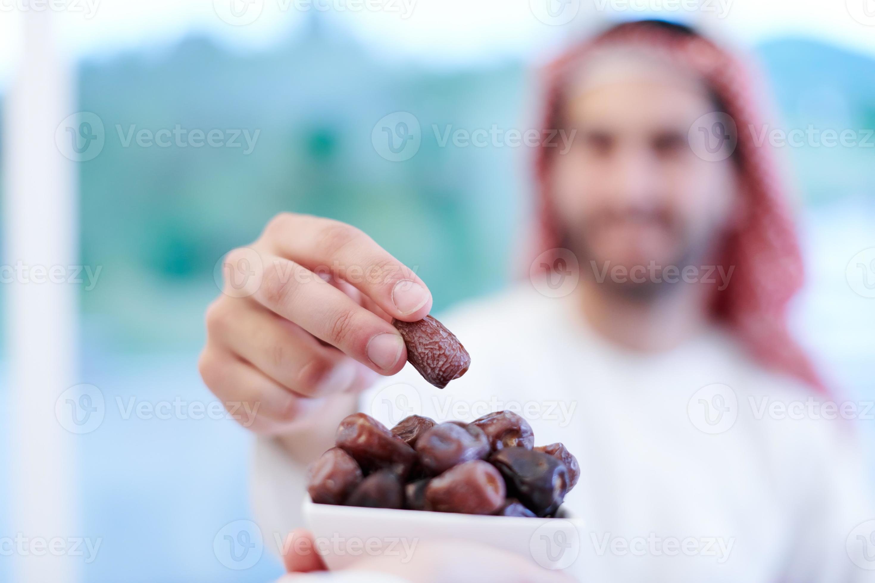 Muslim family having Iftar dinner eating dates to break feast 11003232