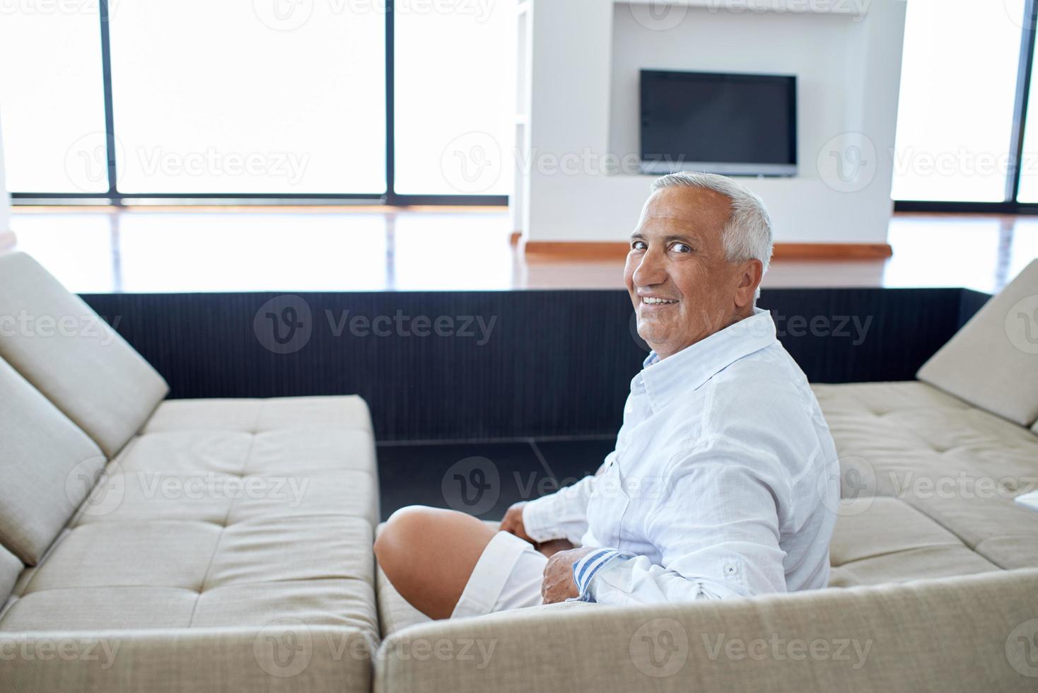Portrait of senior man relaxing in sofa photo
