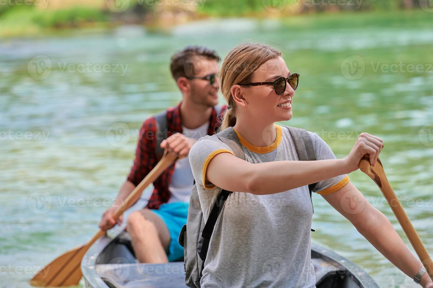 friends are canoeing in a wild river photo