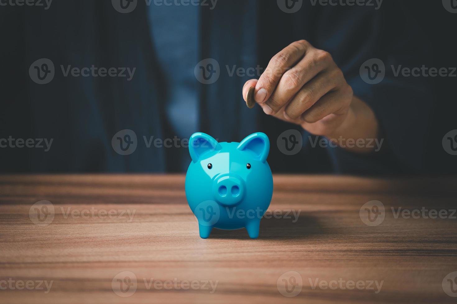 Man putting coin into piggy bank for saving money concept, business finance and investment. photo