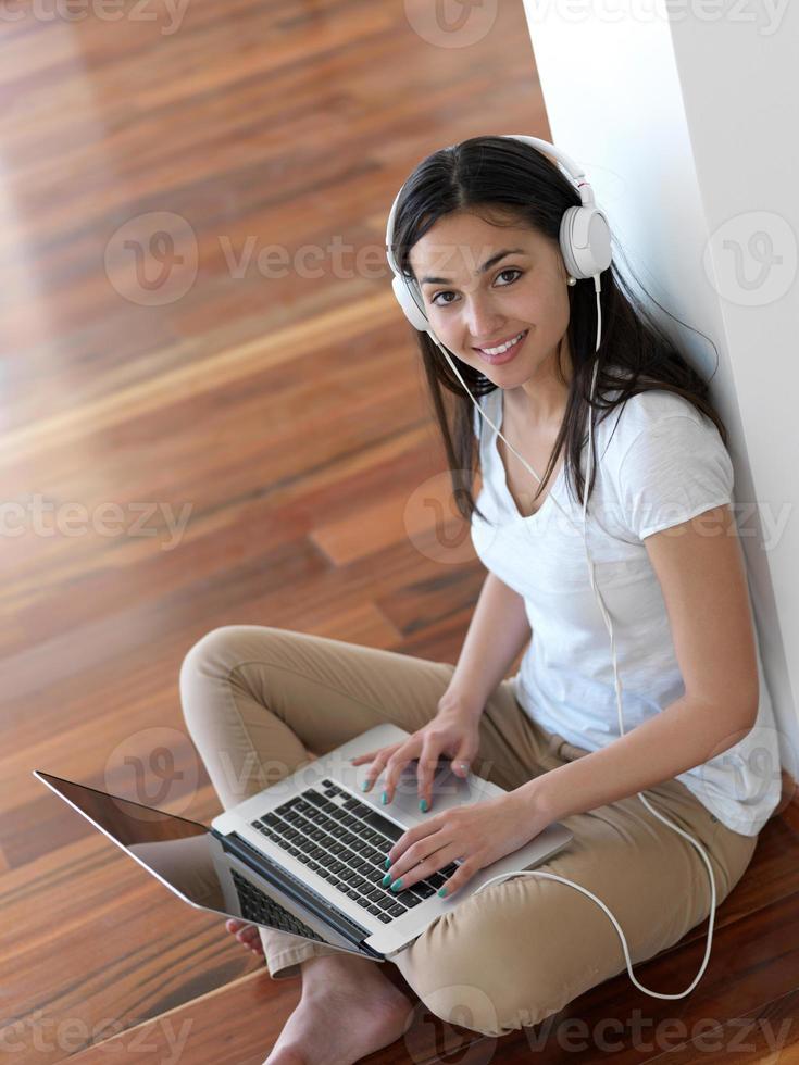 relaxed young woman at home working on laptop computer photo