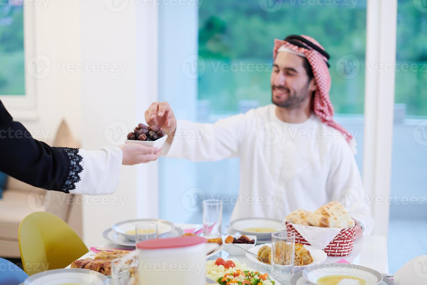 Muslim family having Iftar dinner eating dates to break feast photo