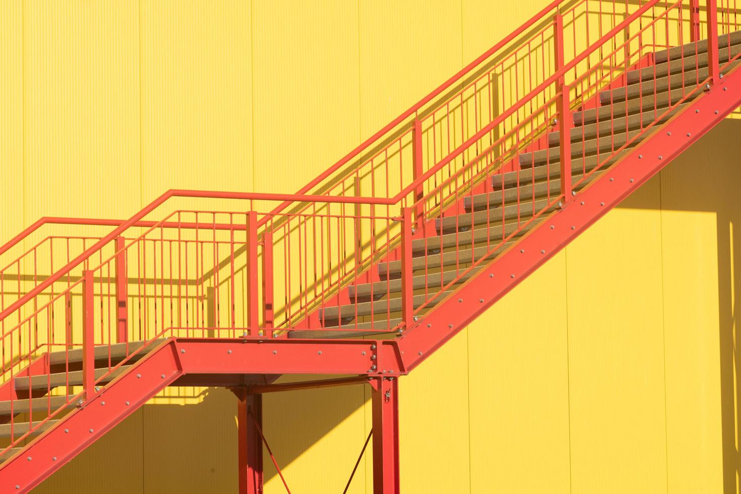 oberhausen,alemania,2022 - escalera roja al sol en la pared amarilla foto