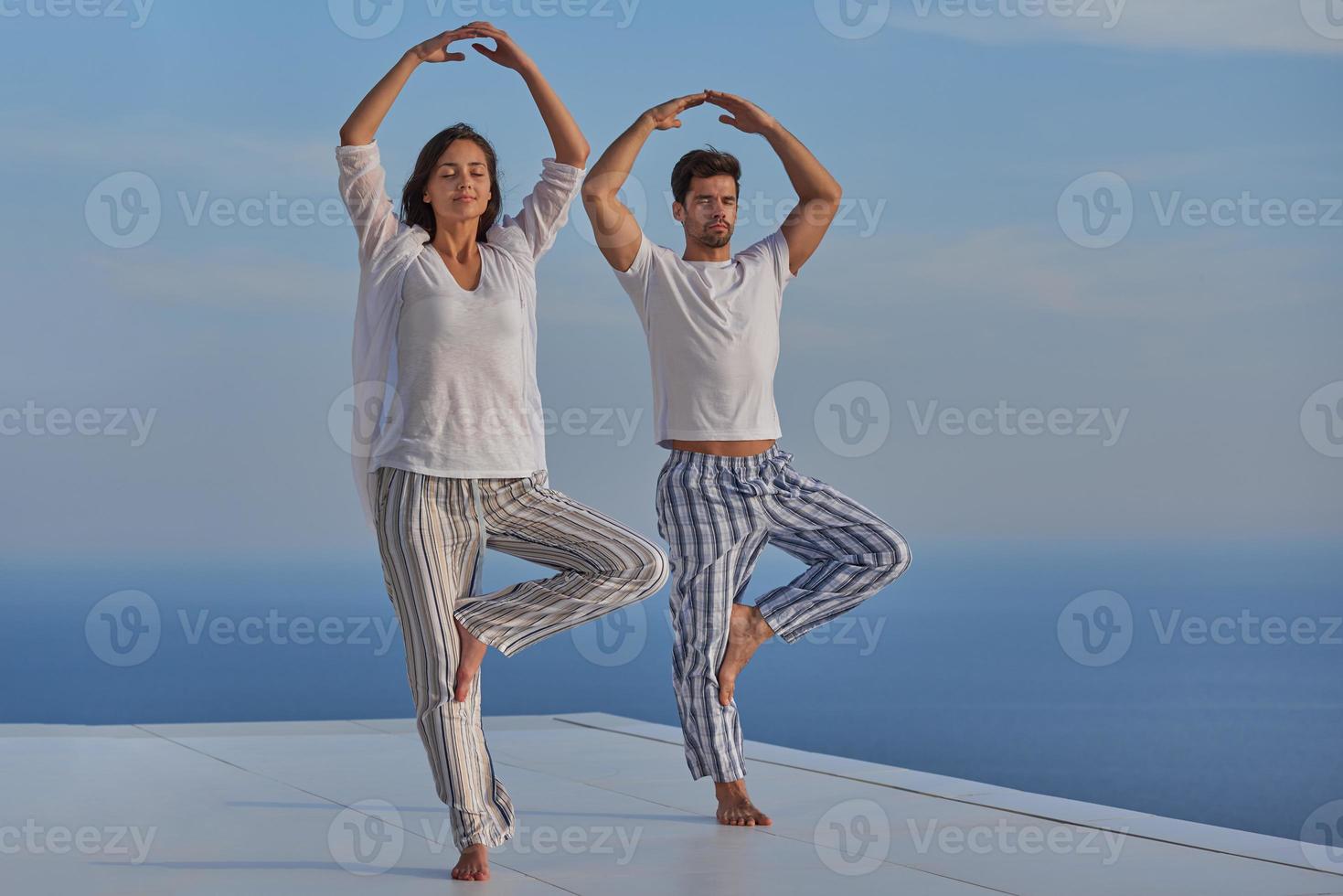 young couple practicing yoga photo