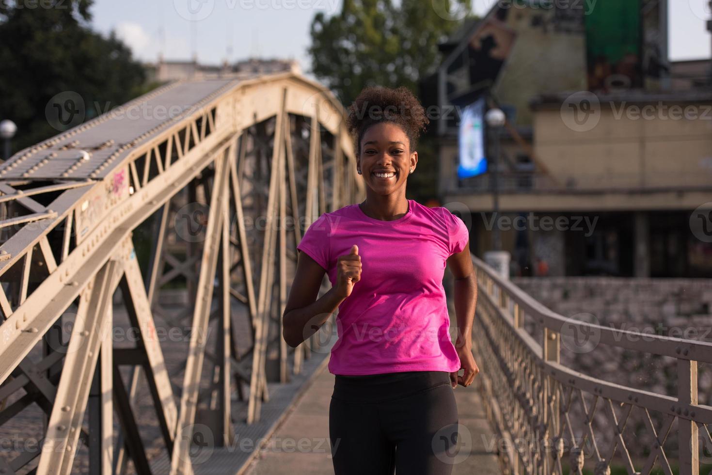 african american woman running across the bridge photo