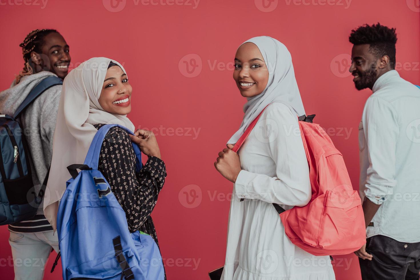 A group of African Muslim students with backpacks posing on a pink background. the concept of school education. photo