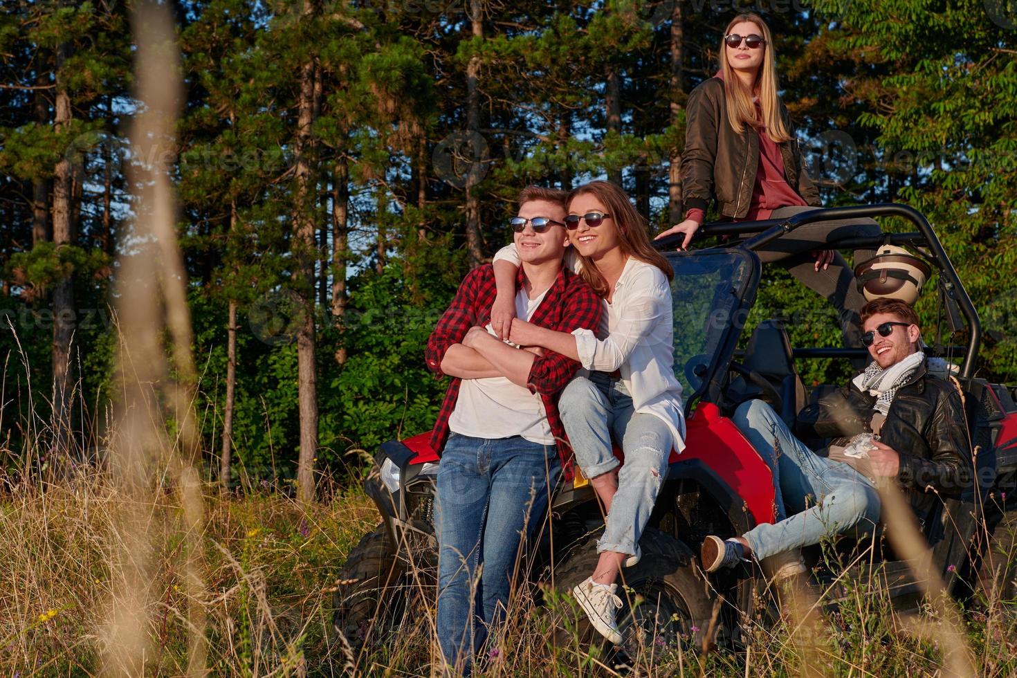 group young happy people enjoying beautiful sunny day while driving a off road buggy car photo