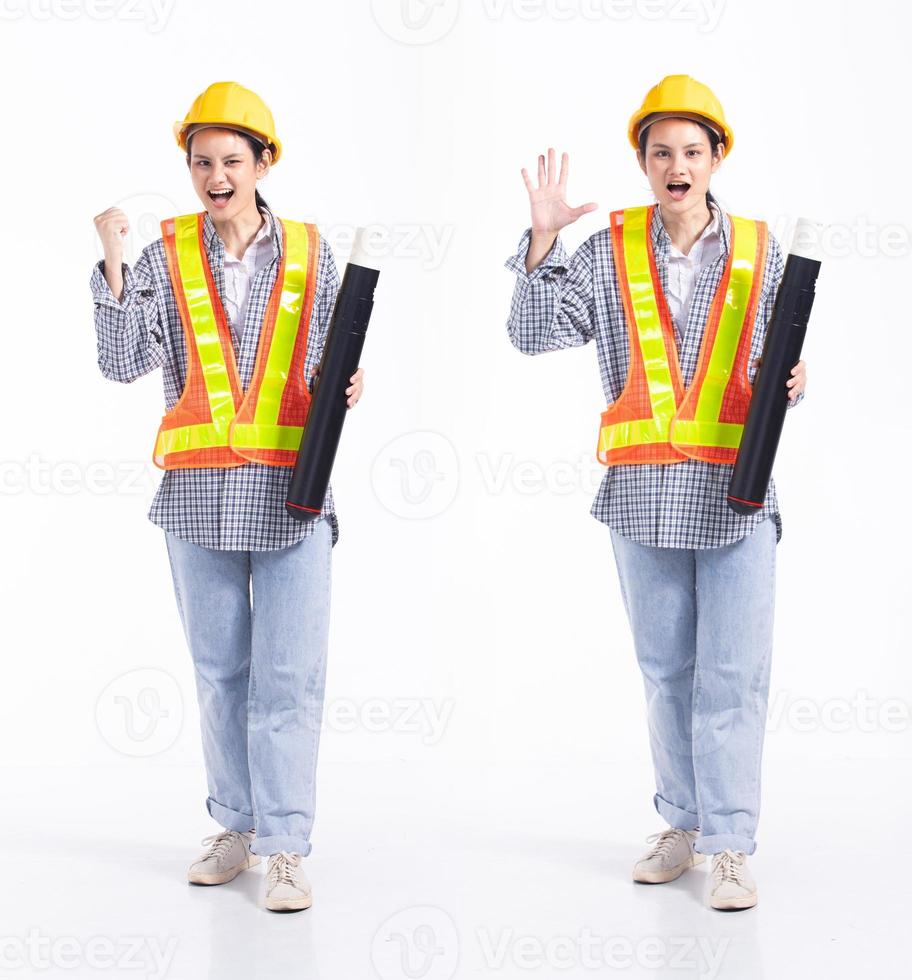 Full length 20s young Mix Race engineer contractor Woman, wow surprise glad, wear safety vast hardhat blueprint. Office female stands feels smile happy over white background isolated photo