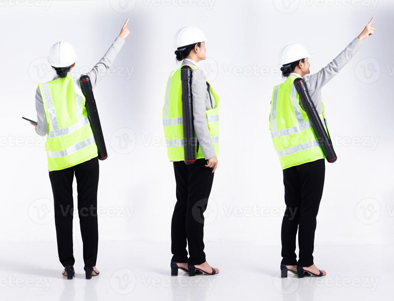 Full length 20s young Mix Race engineer architect client Woman, pointing finger in empty Air, wear safety vast hardhat tablet. Office female stands feels smile happy over white background isolated photo