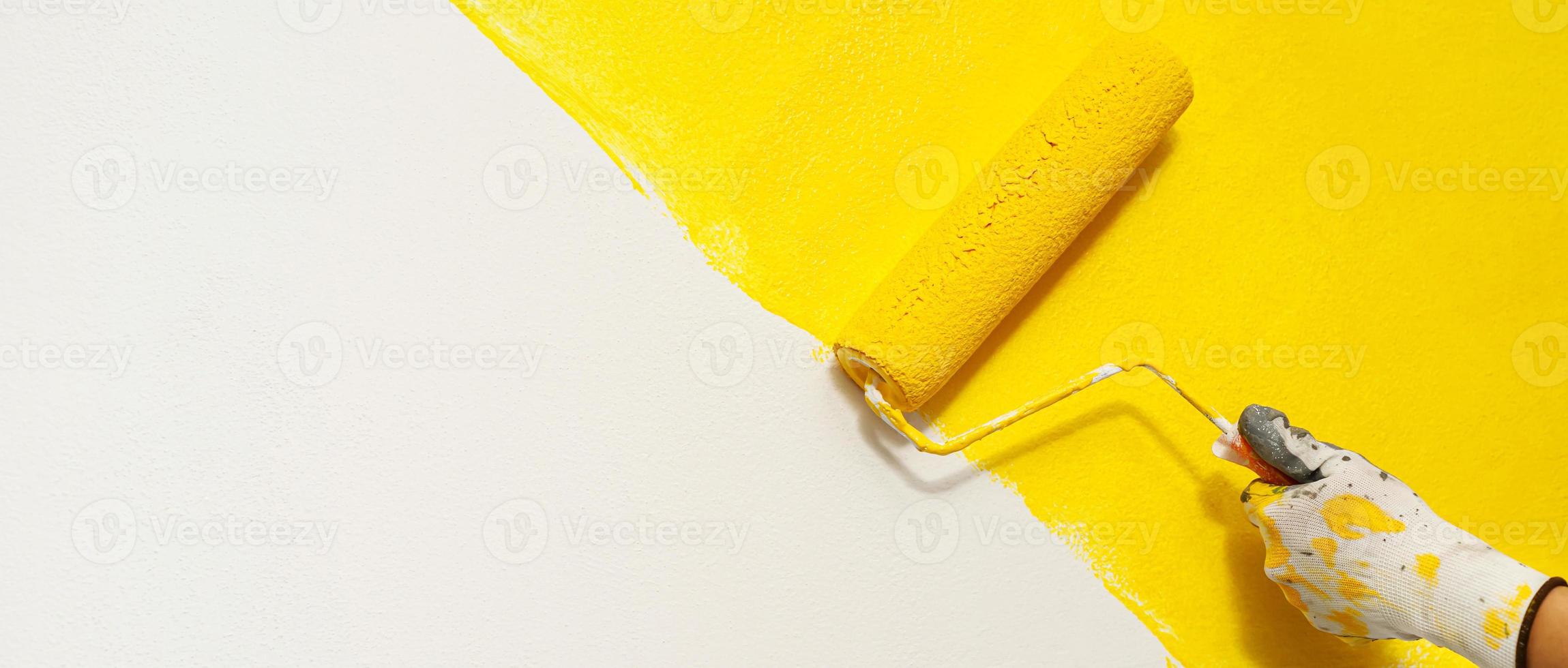 Painter is painting the interior wall yellow photo